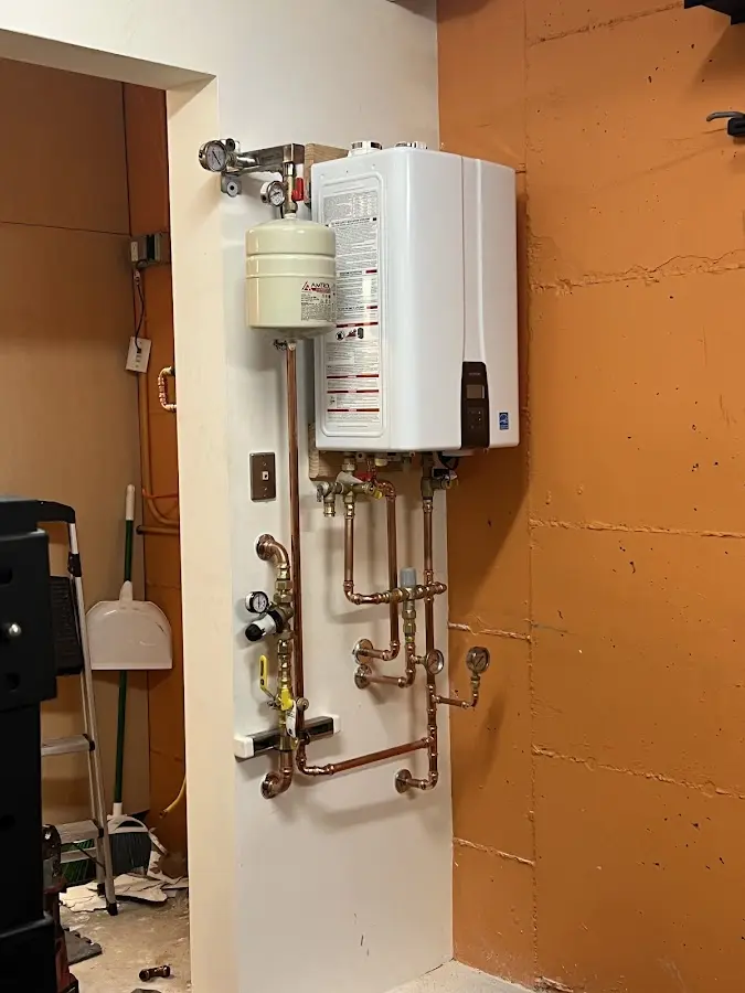 Plumbing technician inspecting water heater connections in Rockwood